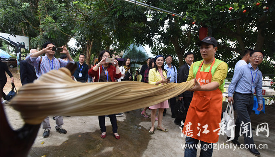 图片:11月25日,诗人们观赏遂溪糖胶现场手工艺制作。 记者 殷翊展 摄
